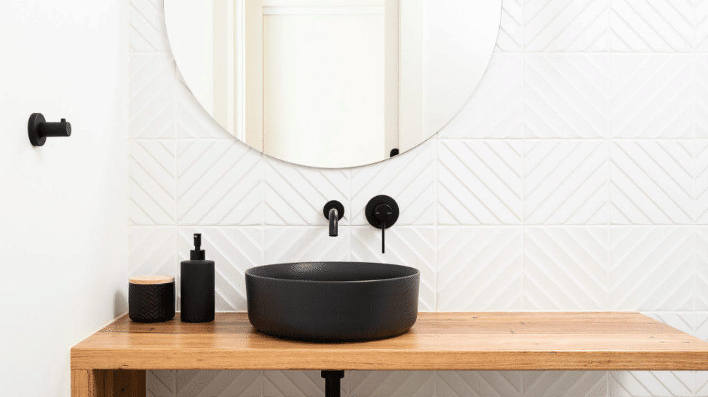 A bathroom vanity from the Kew High Street South Project features pristine white tiles and a black sink.
