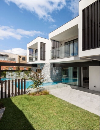 A magnificent modern house with a sparkling pool and elegant outdoor area illustrates masterful renovation by Spacemaker.