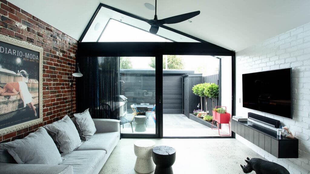 A renovated living space in Albert Park features a patio area complemented by stylish decor and contrasting black accents.