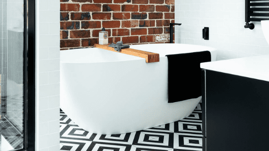 Black and white bathroom suite with brick wall