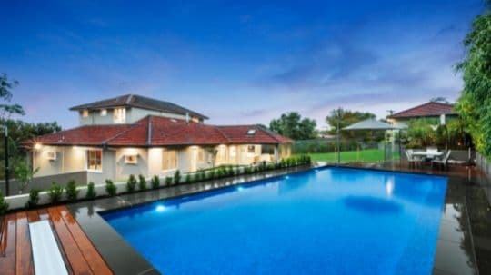 A luxurious home renovation in Glen Iris, Melbourne, by Spacemaker, displaying an expansive pool and inviting deck area.