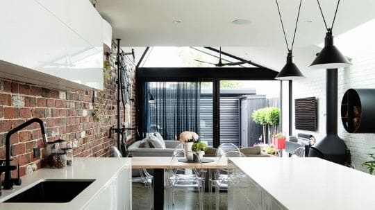 A modern kitchen renovation in Albert Park, Melbourne, by Spacemaker features brick walls and chic home decor.