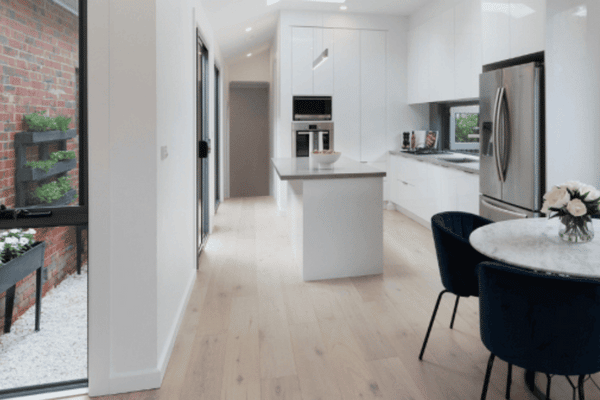 A sleek kitchen and dining area renovation by Spacemaker features modern black and white decor that exudes sophistication.