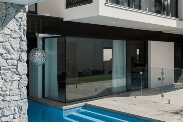 A luxurious outdoor pool area renovated by Spacemaker Home Extensions displays contemporary style and comfort.