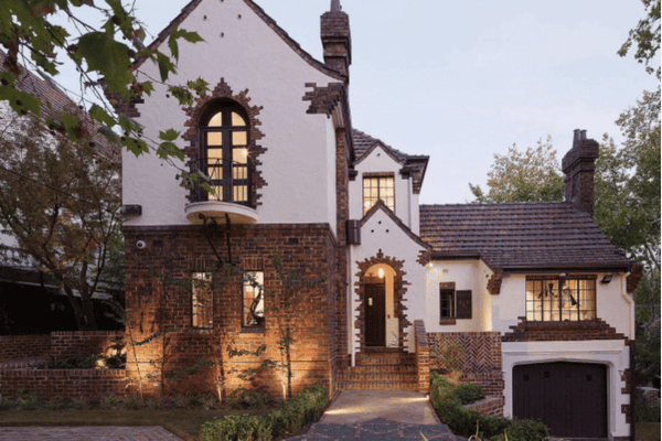 A charming brick home surrounded by lush greenery showcases Spacemaker's dedication to quality building practices.