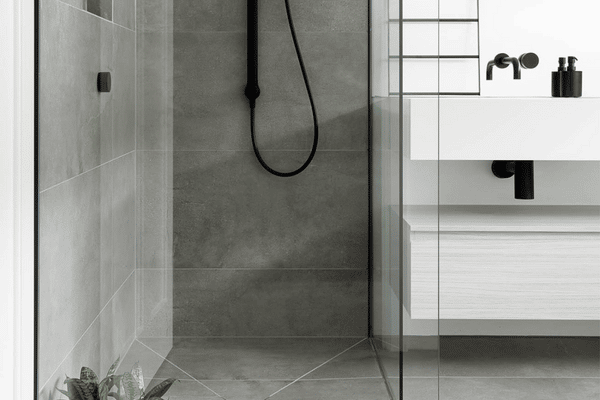 A pristine bathroom renovation by Spacemaker boasts a state-of-the-art shower and vanity adorned with accessories.