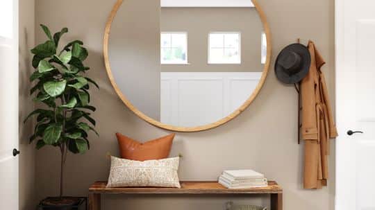 A chic entryway by Spacemaker includes an elegant coat rack, mirror, table, and a plant, symbolizing style and warmth.