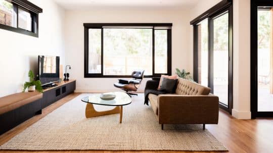 A serene home renovation features a minimalistic living room design and high-quality, modern furniture.